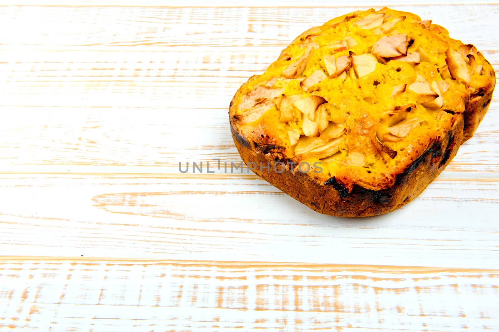 Fresh bakery. Baked pie with apples on white wooden background.