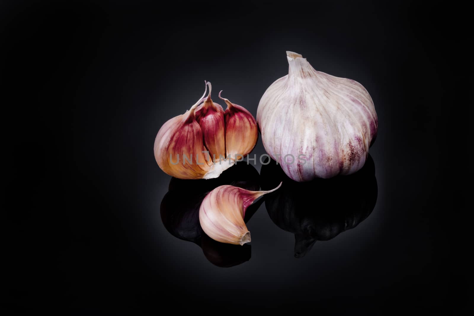 Garlic with reflection on black background.