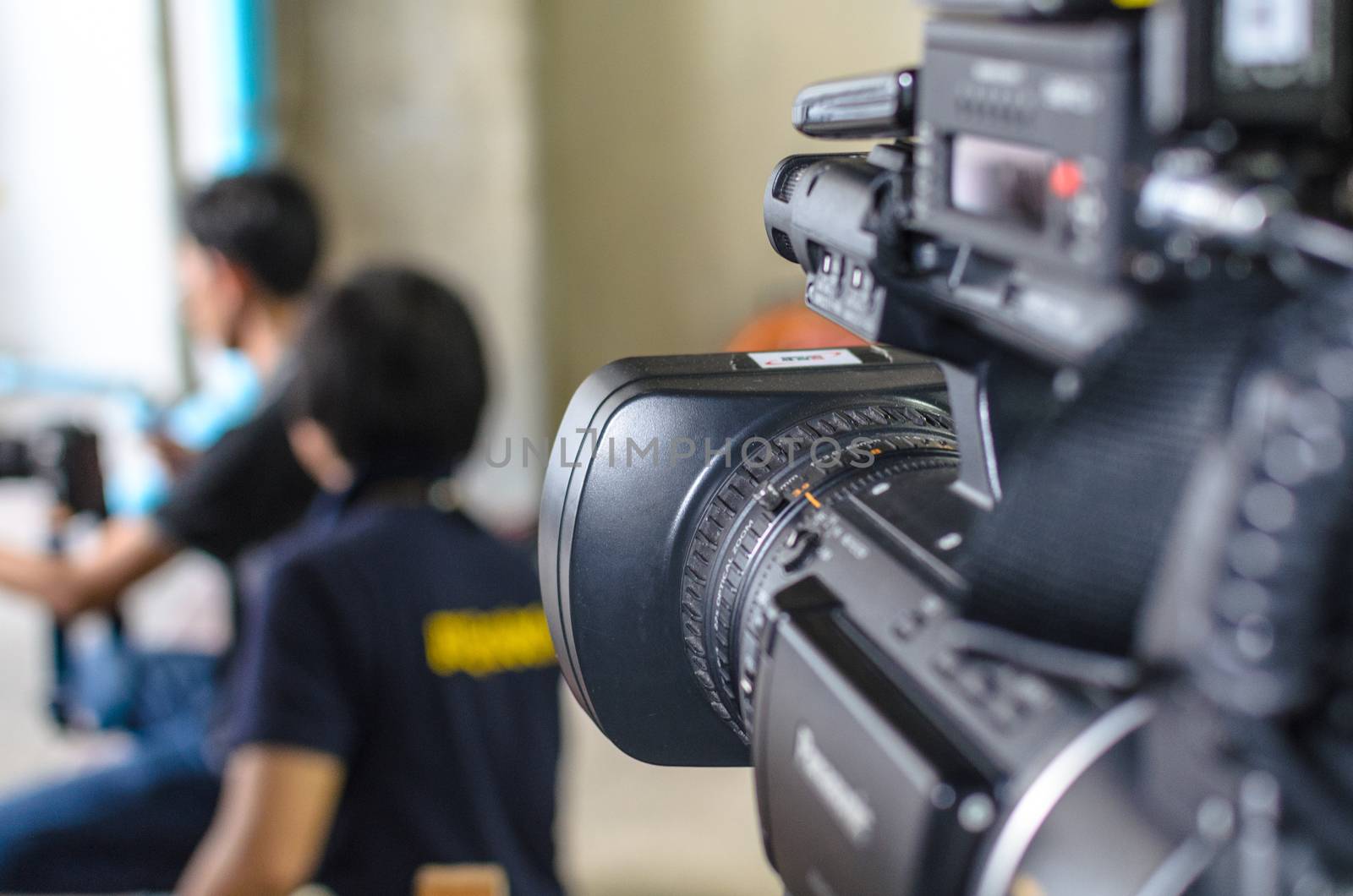 Video Camera has focus behind the photographer for broadcasting and recording.