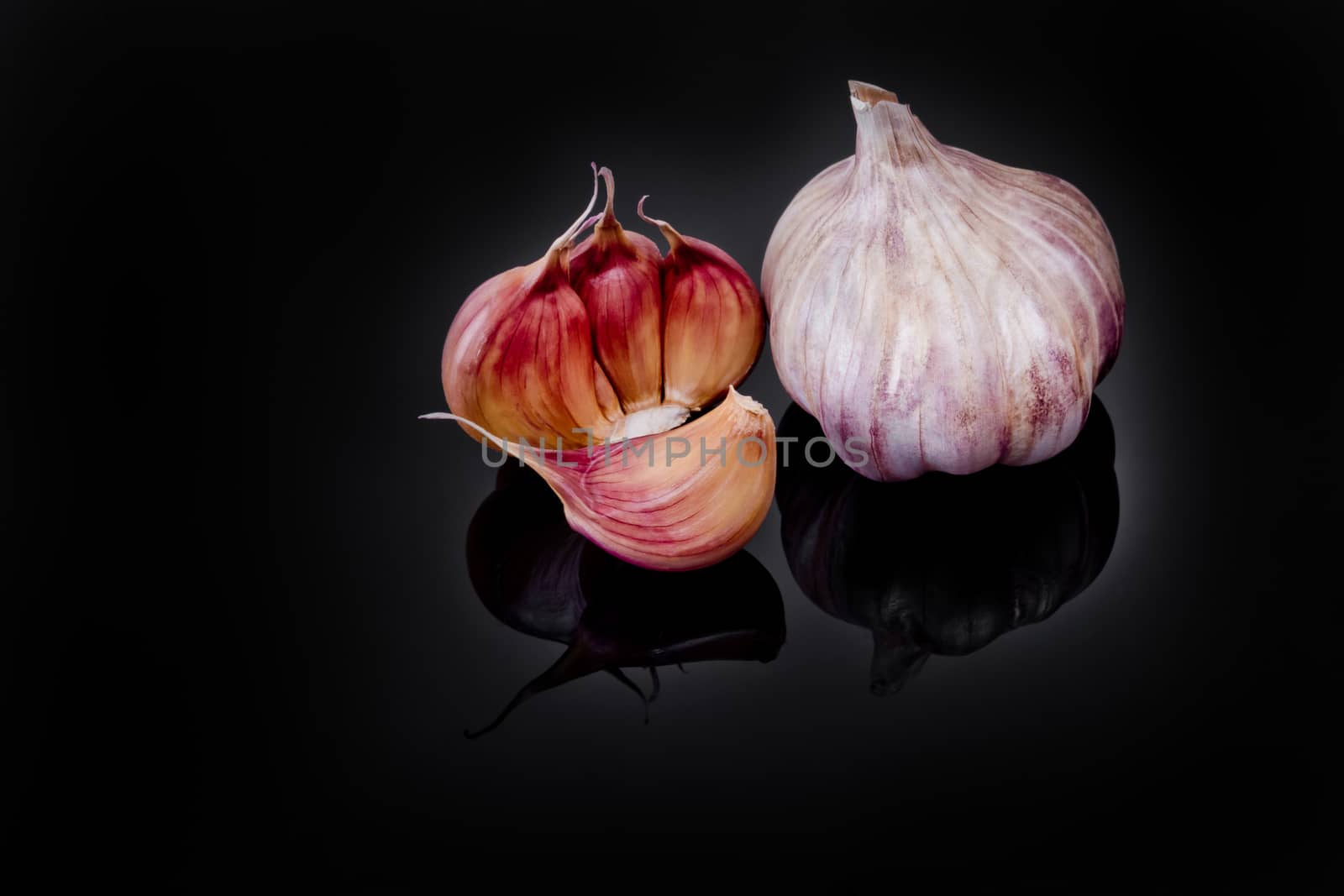 Garlic with reflection on black background.