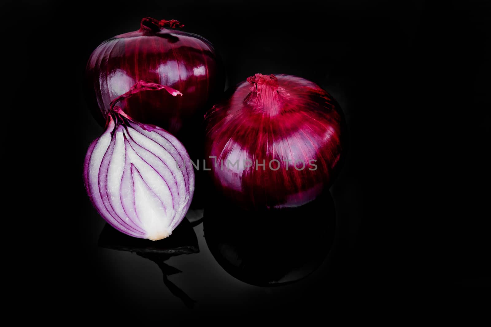 Red onion and half slice on black background with reflect.