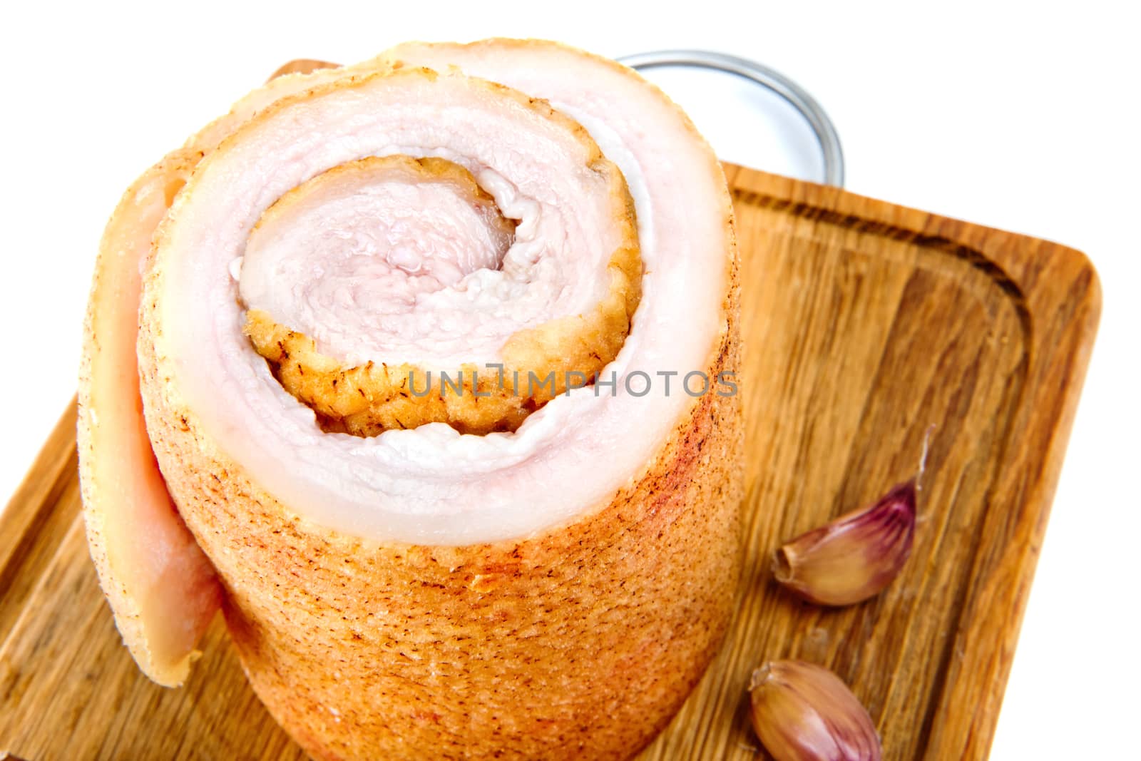 Pork belly with garlic on wooden board isolated on a white background.