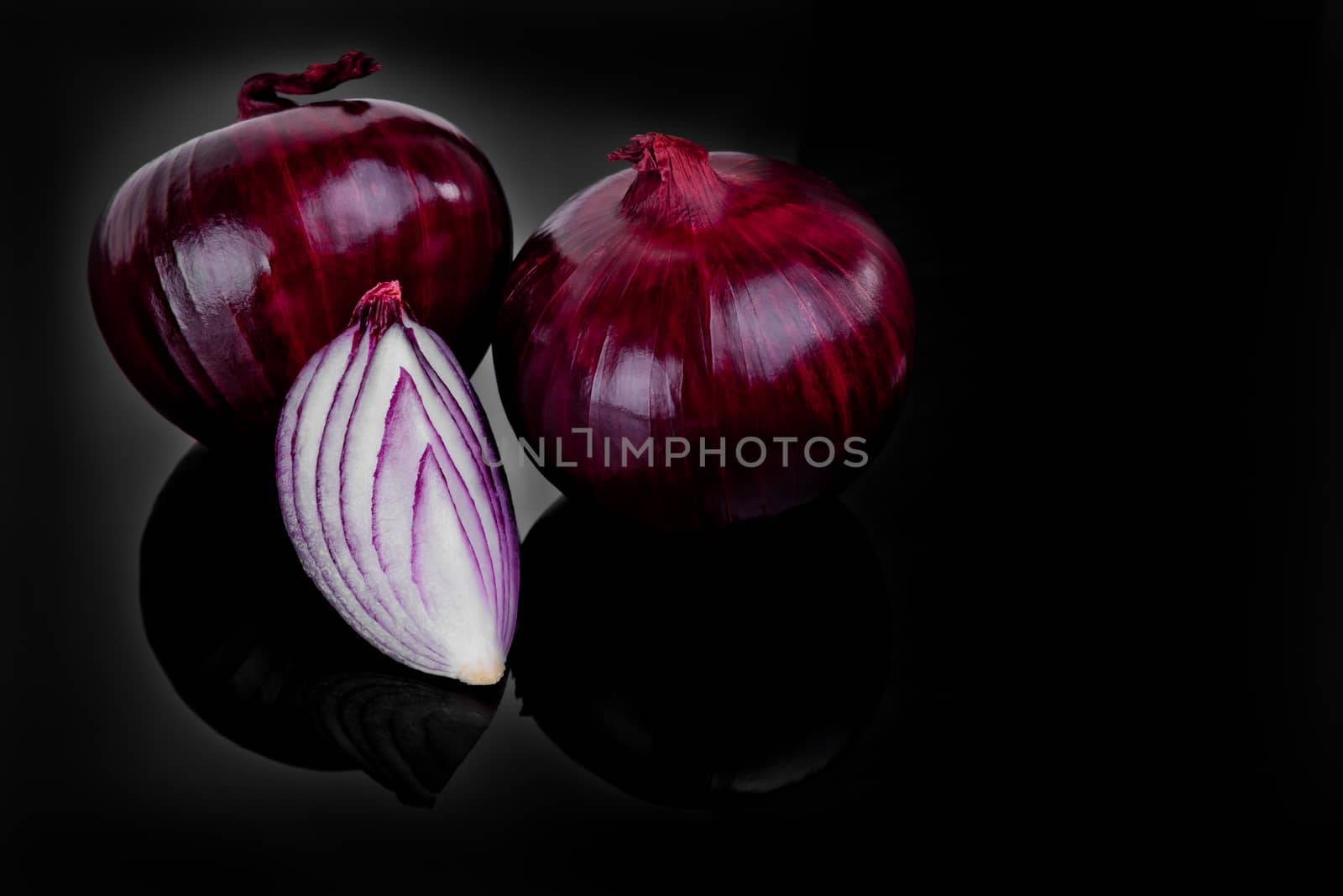 Red onion and half slice on black background with reflect.