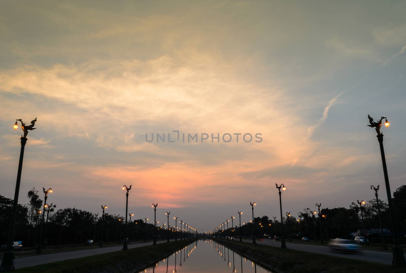 Sunset over a highway Utthayan Road and reflection on the river in Bangkok Thailand.