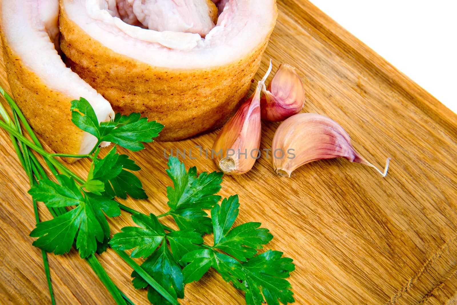 Pork belly with garlic and parsley on wooden board isolated on a white background.