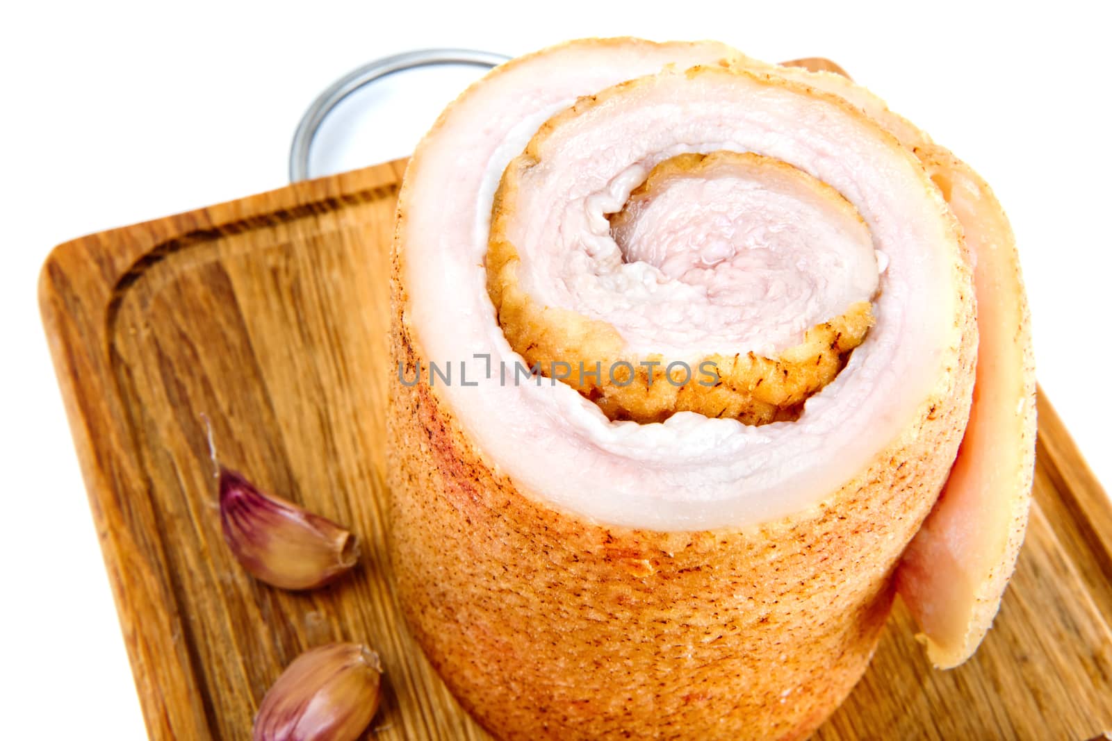 Pork belly with garlic on wooden board isolated on a white background.