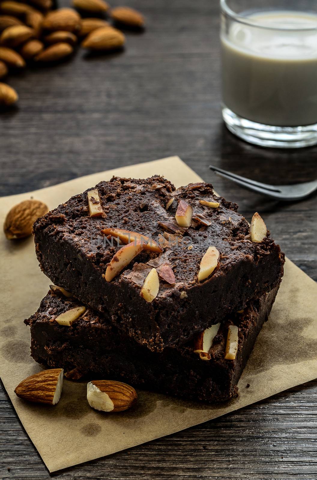 Chocolate Brownie with Almonds on the wood table has ready to served in the dessert time.