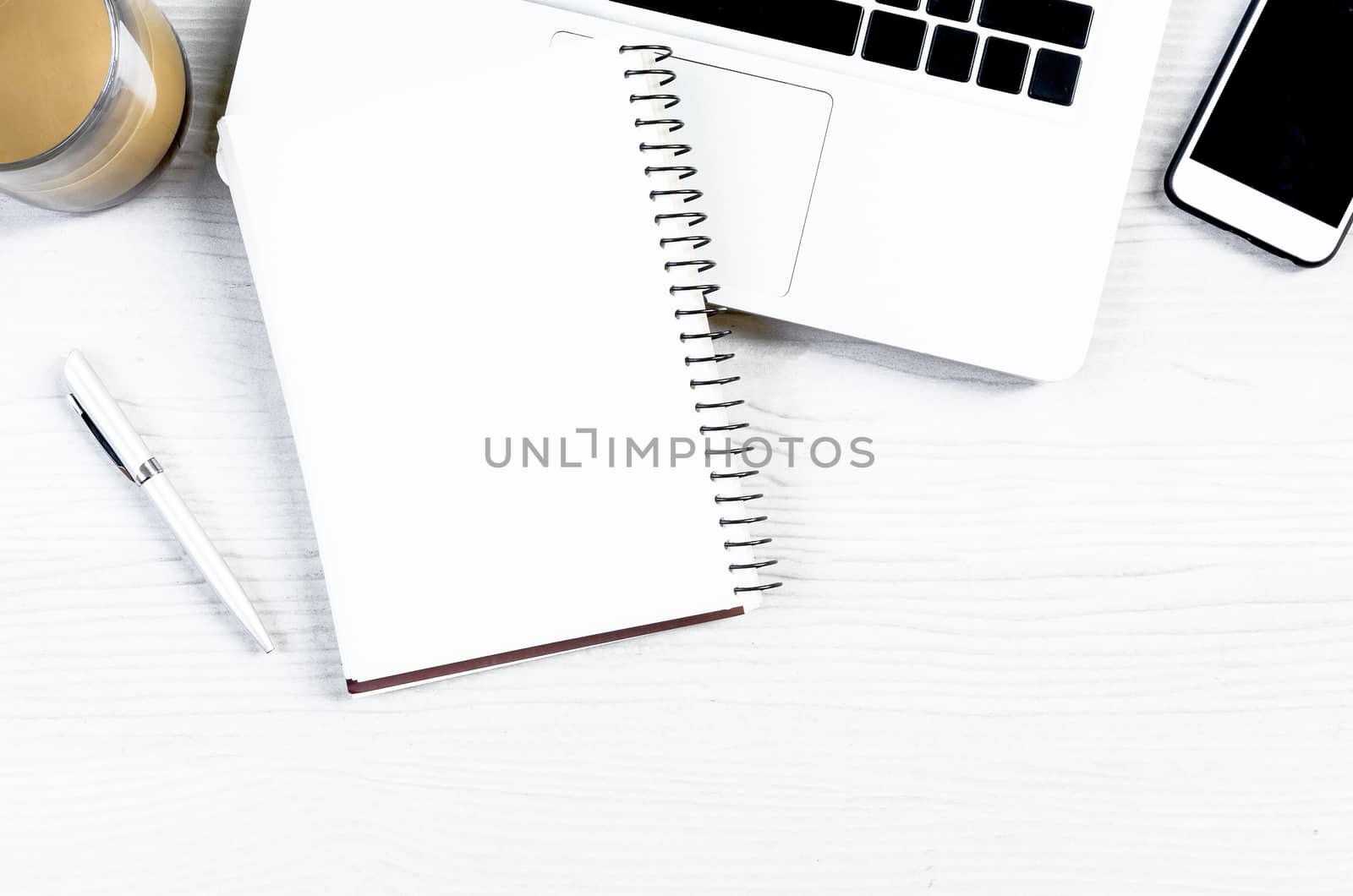 White wood office desk table with a lot of equipment for working in top view and copy space.