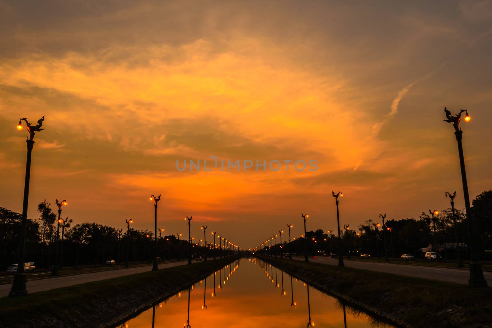 Sunset over a highway Utthayan Road and reflection on the river in Bangkok Thailand.