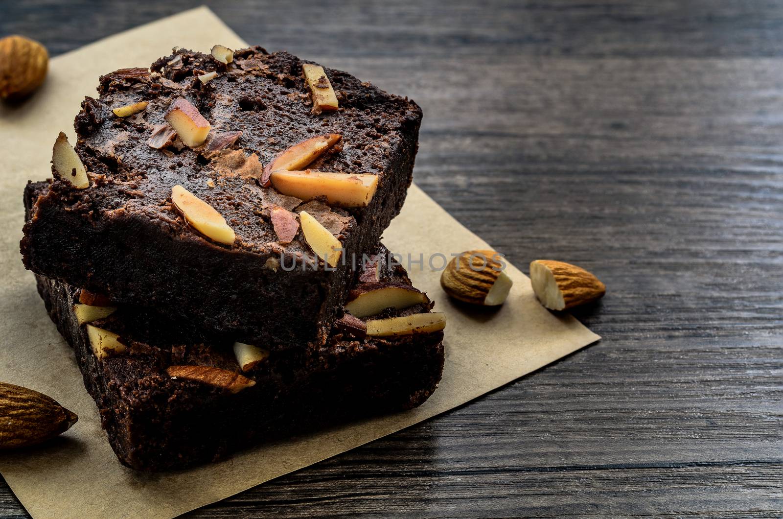 Chocolate Brownie with Almonds on the wood table has ready to served in the dessert time.