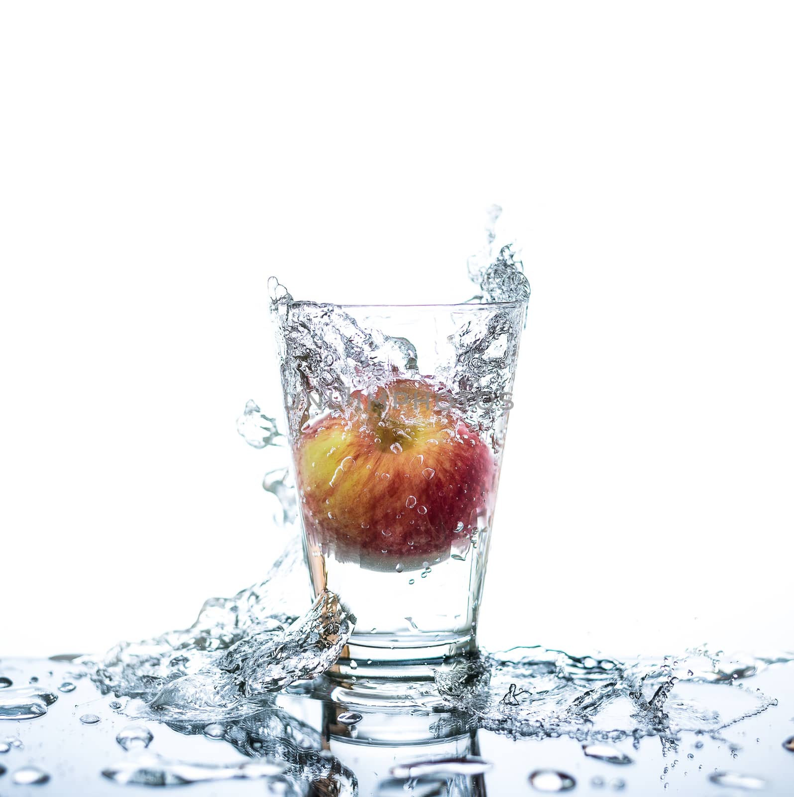 Red apple has droping to the glass and splashing water around th by animagesdesign