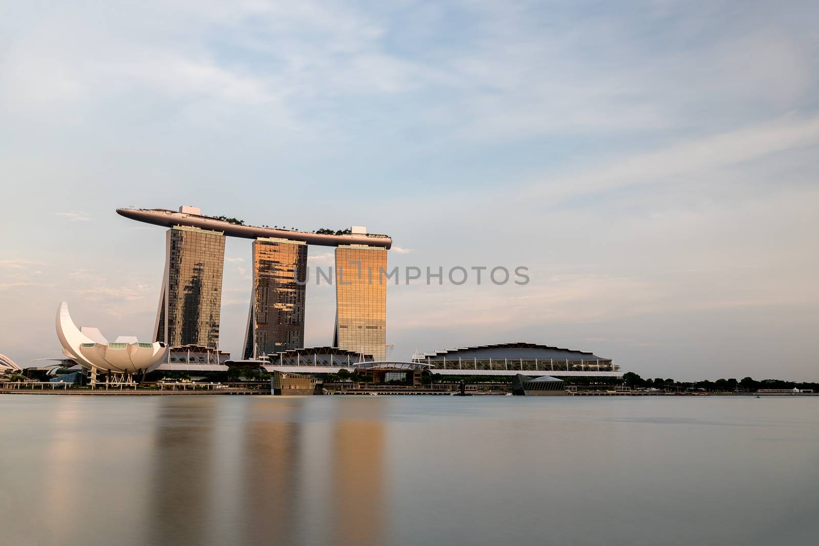 MARINA BAY SANDS, SINGAPORE - May 23, 2017: Marina Bay Hotel at Singapore in the sunset time with blue sky background and waterfront reflection.