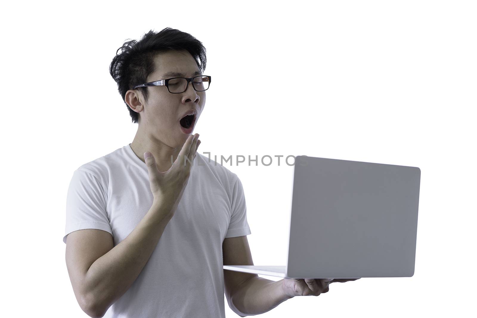 Asian handsome man with white shirt has wake up with sleepy and holding computer laptop for working with lazy and bored before going to start the work in the morning isolated on white background and clipping paths.