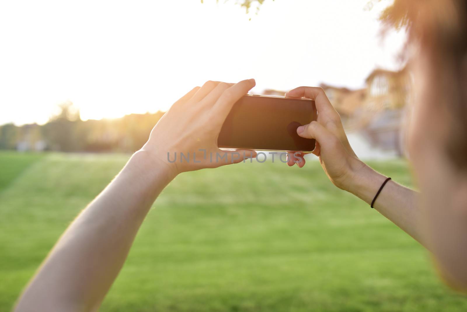 close-up guy takes pictures of nature, beautiful views on his smartphone. summer mood