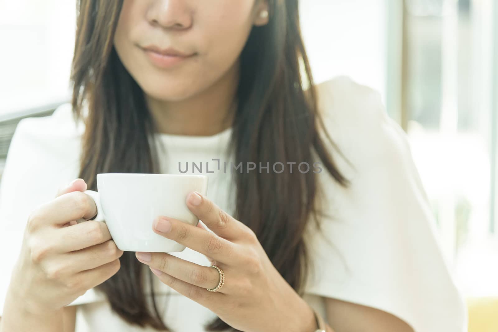 A coffee cup and beautiful asian married businesswoman in the mo by animagesdesign