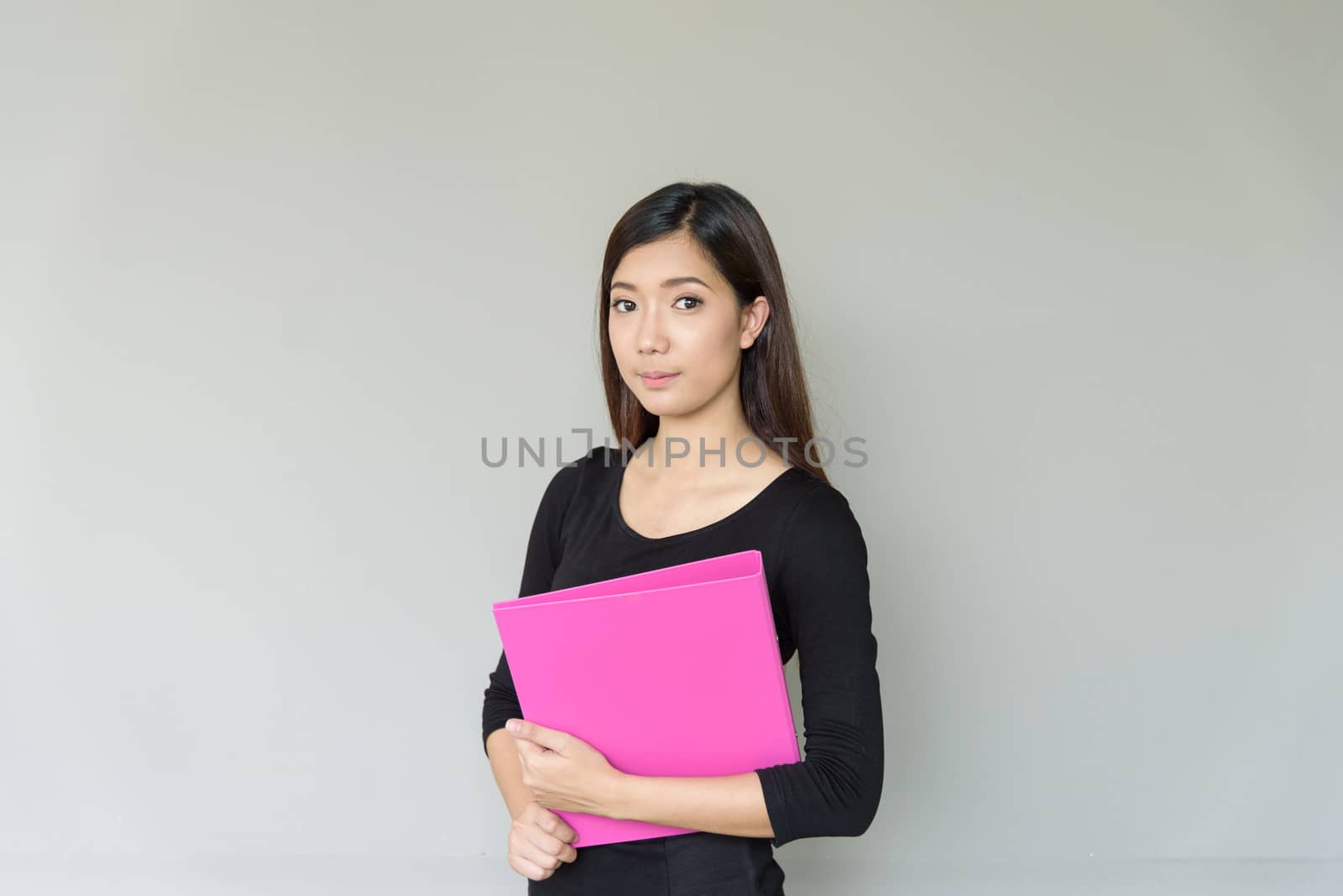 A businesswoman with black shirt and holding pink folder isolate by animagesdesign