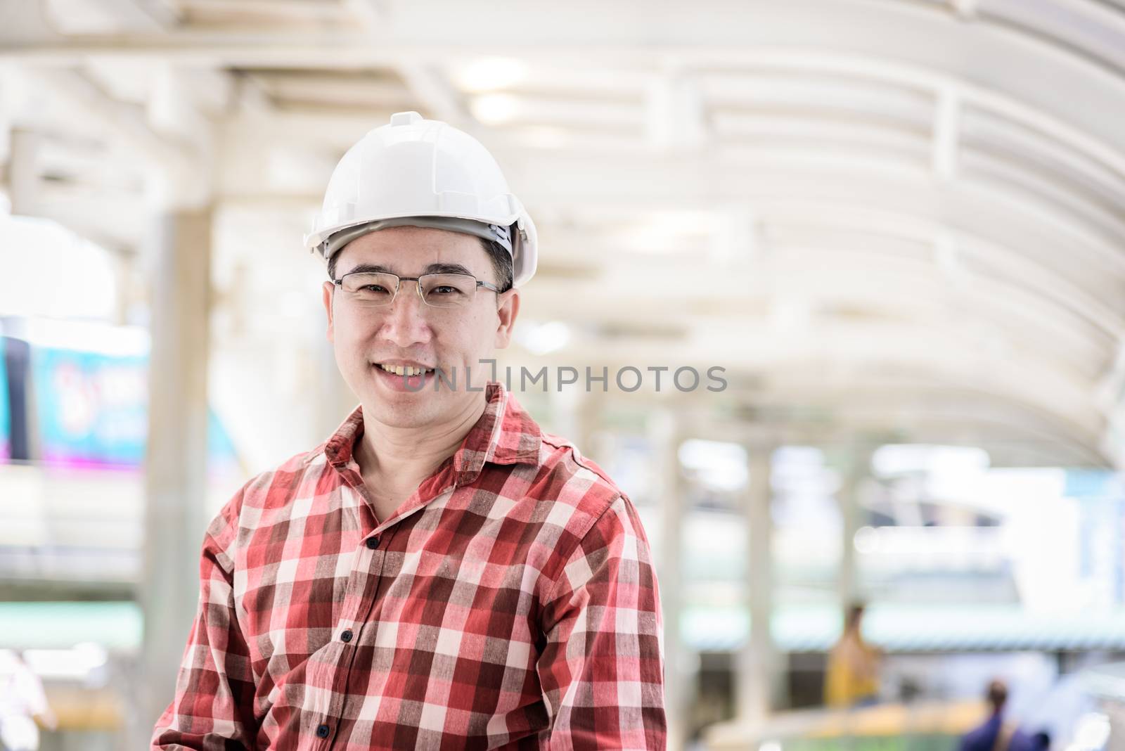 Asian business and engineer man with red scott shirt has planning and working for design buiding and city.