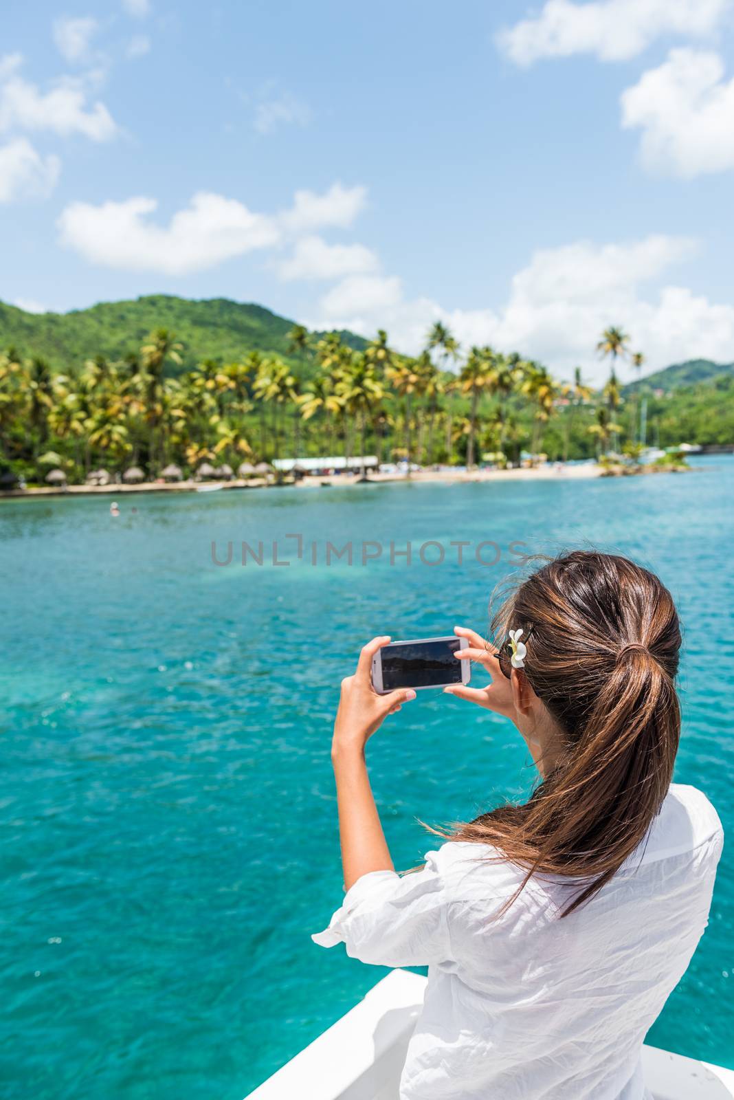 Woman on shore excursion boat tour taking phone pictures of popular tourist attraction in St Lucia. Famous beach in Anse Chastanet, Caribbean island. by Maridav