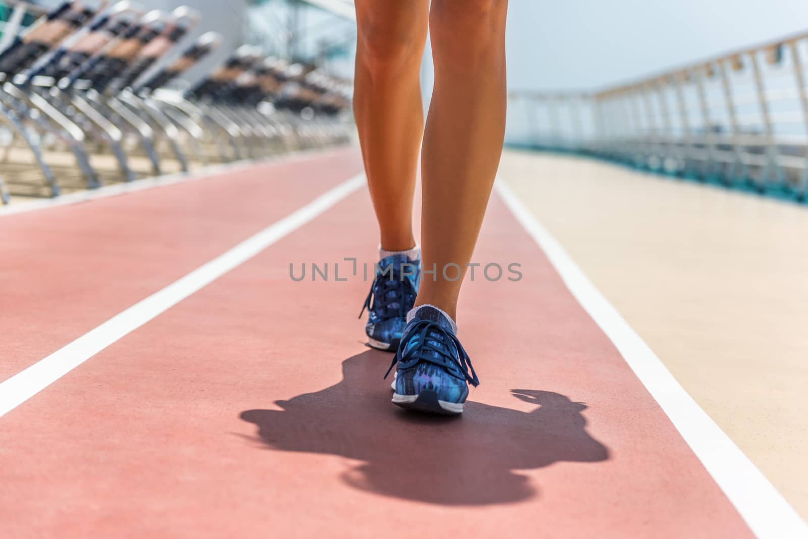 Healthy fitness active woman walking on cruise boat. Running shoes closeup of athlete runner training during vacation on caribbean travel ship.
