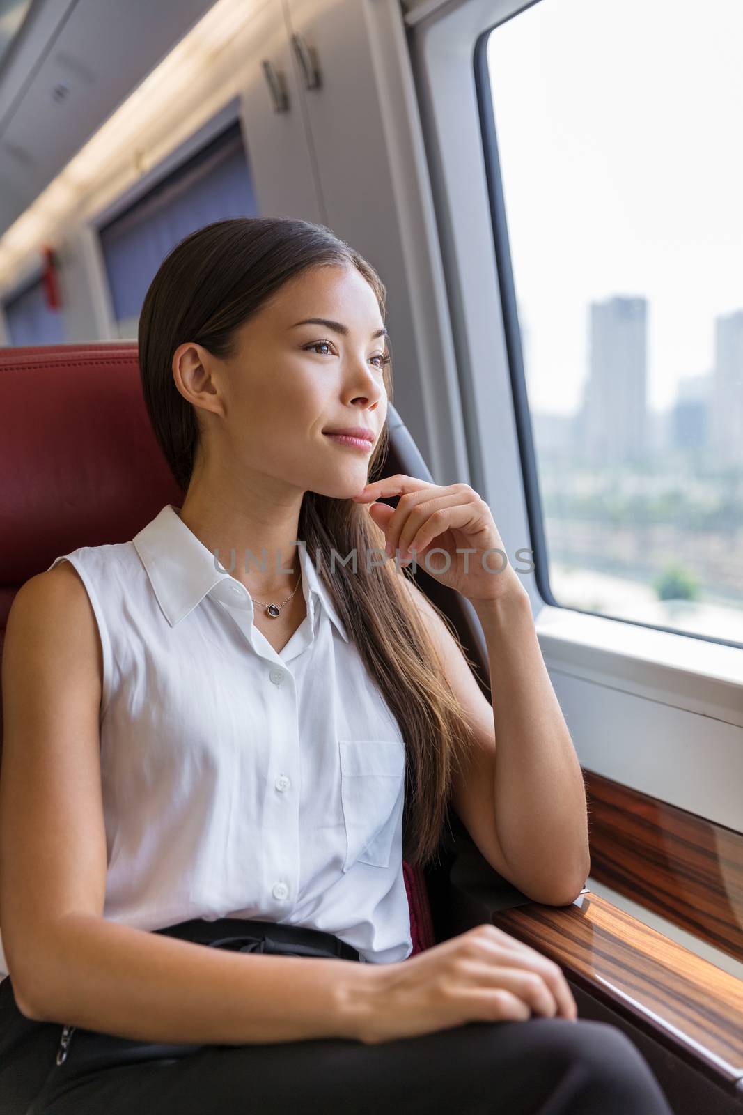 Woman enjoying view in train commute. Woman relaxing enjoying view during morning commute. Business class seat in train. Asian businesswoman pensive looking out the window in travel transport by Maridav