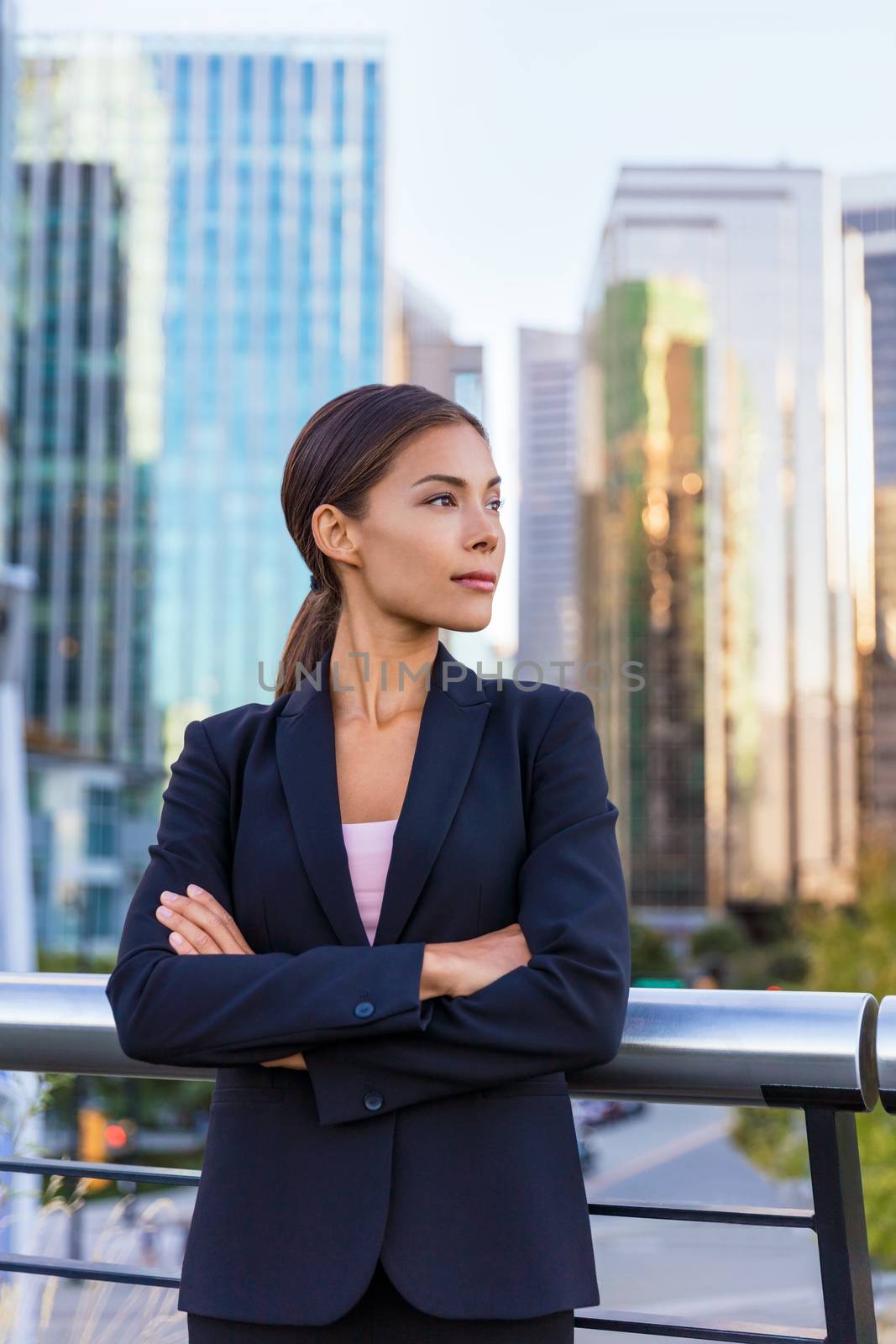 Business woman portrait of young female urban professional businesswoman in suit standing outside office building with arms crossed. Confident successful multicultural Chinese Asian / Caucasian woman.
