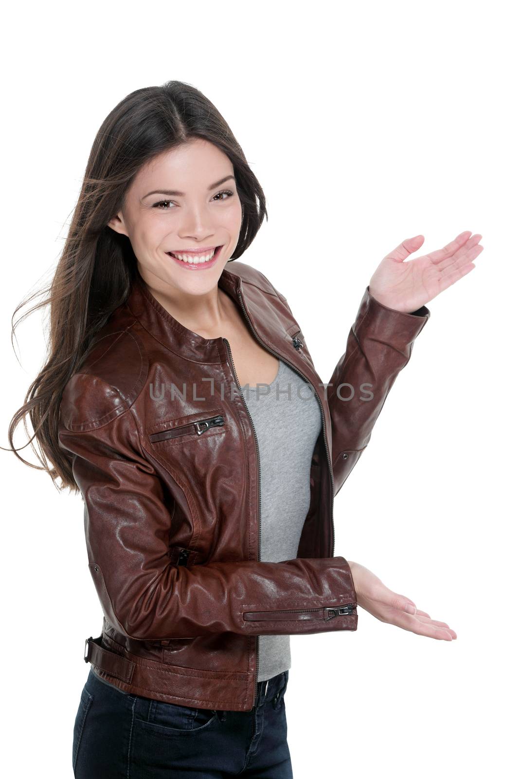 Casual attractive woman presenting blank copy space something on the side with open hands showing copyspace on white background. Asian model cut-out in leather jacket.