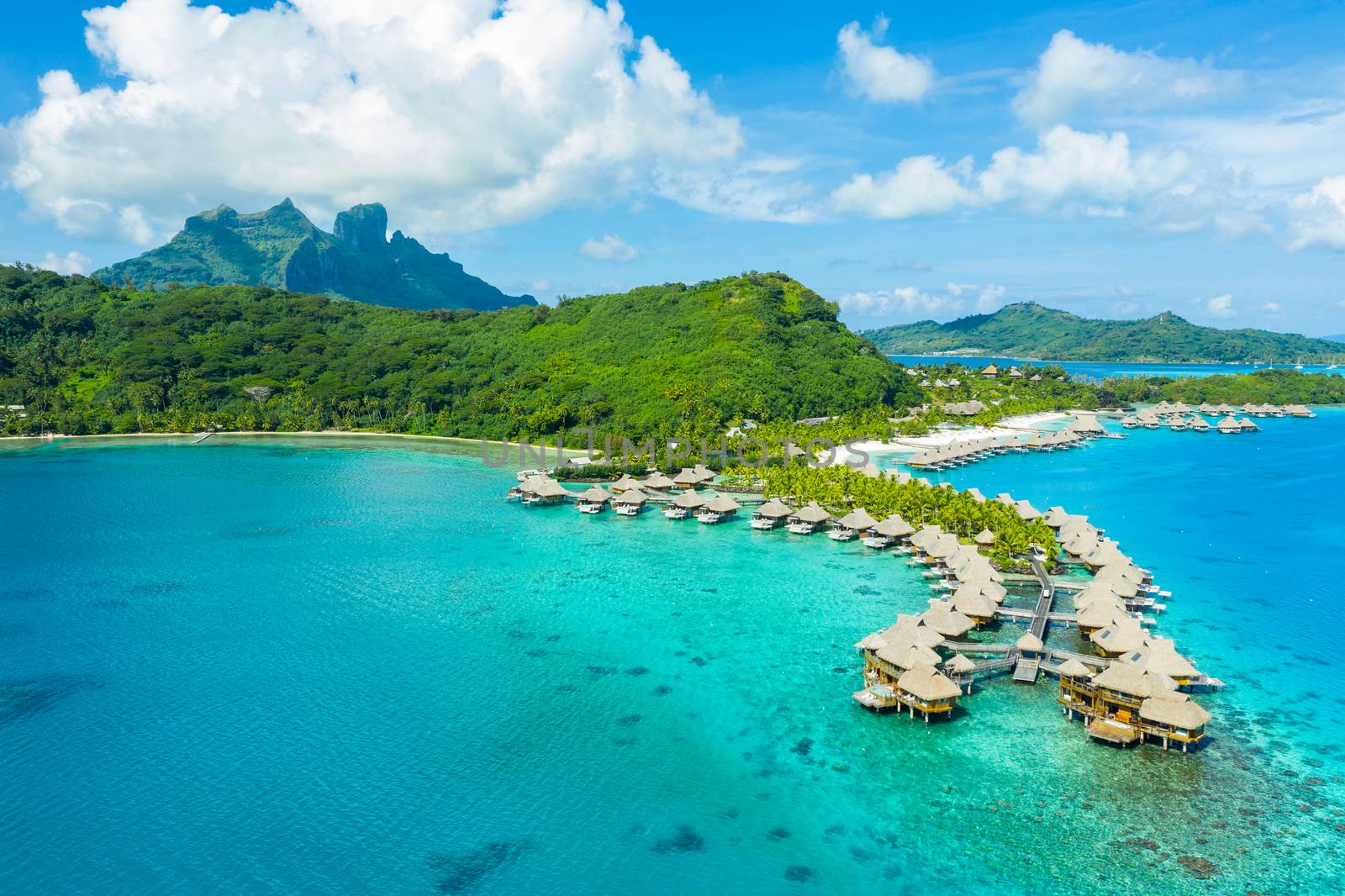 Travel vacation paradise aerial drone video with overwater bungalows luxury resort in coral reef lagoon ocean beach. Aerial of Mount Otemanu, Bora Bora, French Polynesia, Tahiti, South Pacific Ocean