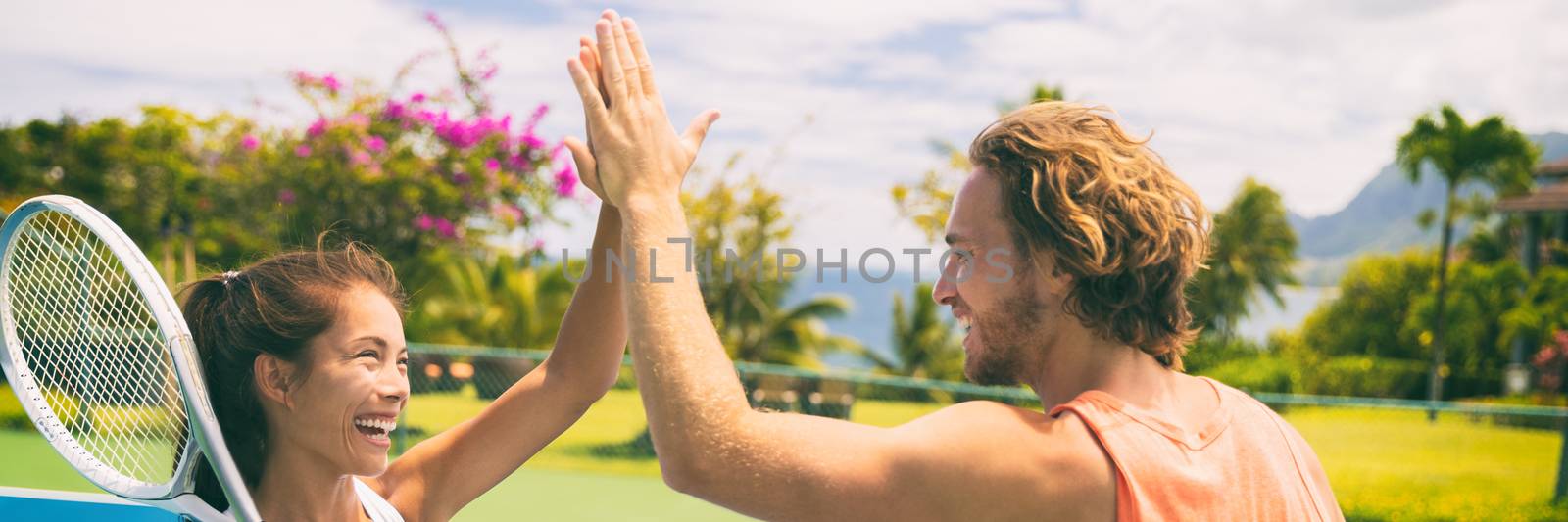 Summer sport tennis players having fun doing high five after game. Healthy lifestyle outdoor living mixed doubles banner panorama.