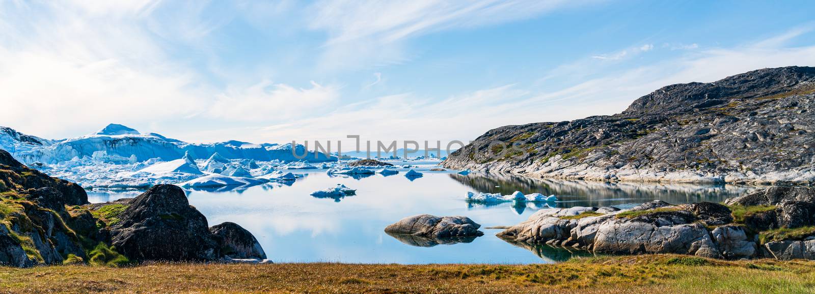 Greenland arctic nature landscape with icebergs in Ilulissat icefjord. Panoramic banner photo of scenery ice and iceberg in Greenland in summer.