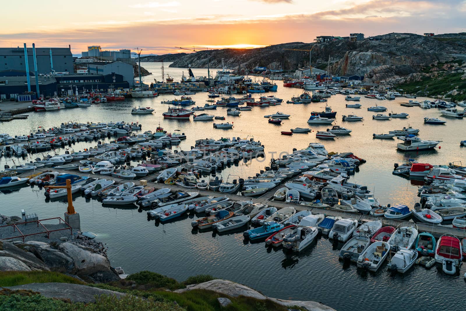 Greenland Ilulissat cruise ship harbor and boat harbour in famous Greenland tourist destination. Sunset city and water view of city in Disko Bay.