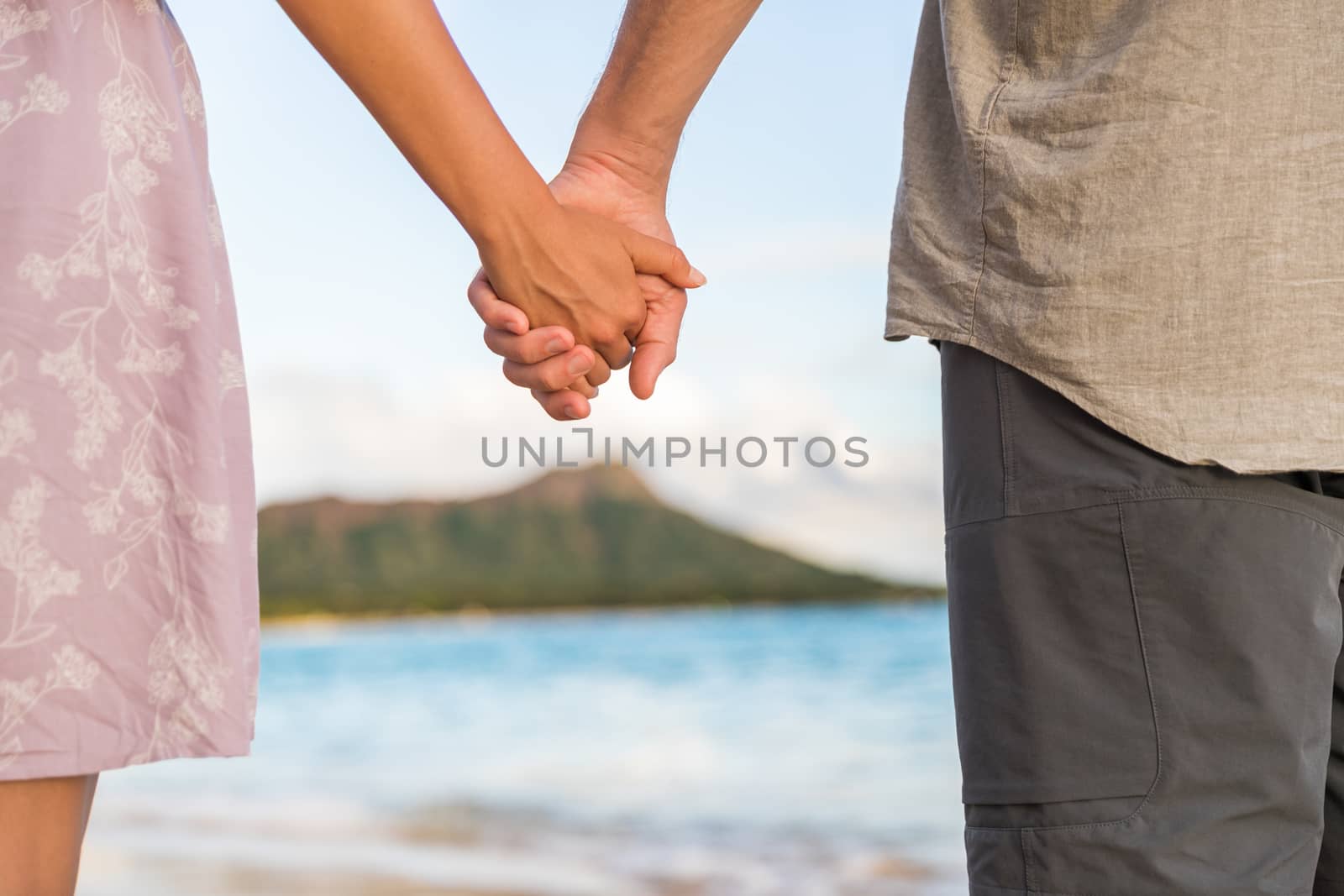 Couple in love holding hands walking on beach relaxing in Waikiki, Honolulu, Hawaii, USA. Summer travel. Diamond head mountain in background by Maridav