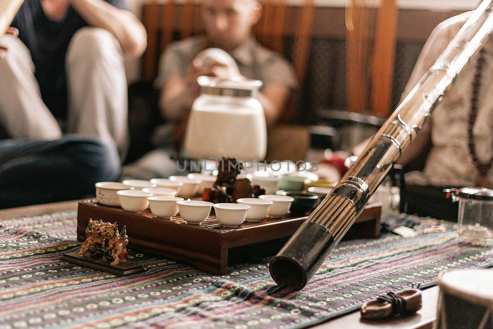 the tea ceremony is conducted by a tea master. tea party in the style of boho, hippie. tea cups on a special wooden coffee table. Preparation of masala tea. Tea is prepared on the fire. a didgeridoo. by Pirlik