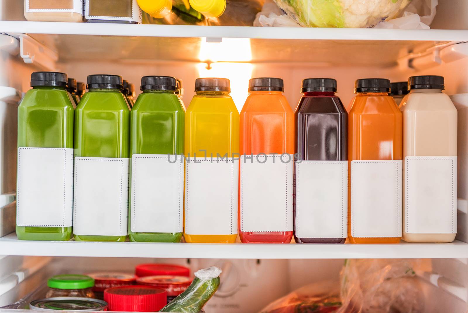 Juicing cold pressed vegetable juices for a detox cleanse diet. Dieting bydrinking organic fruits and vegetables juice made fresh and delivered in bottles at home in fridge by Maridav