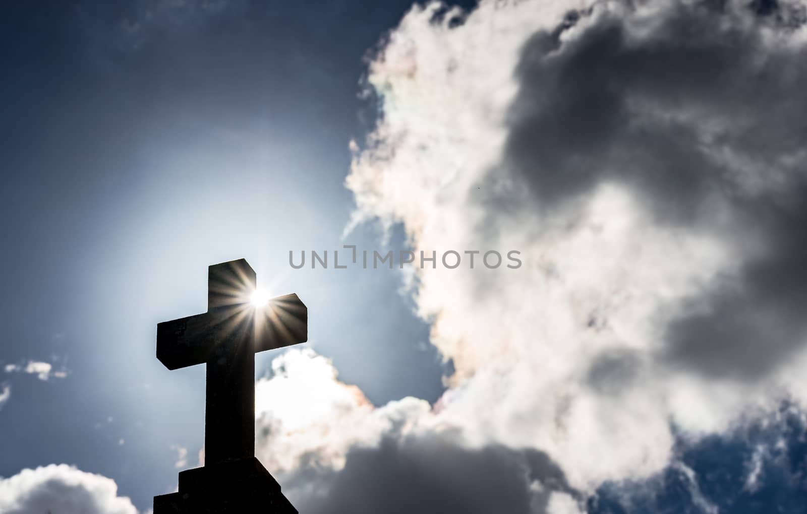 Cross against cloudy sky with sunlight, religion christianity concepts background