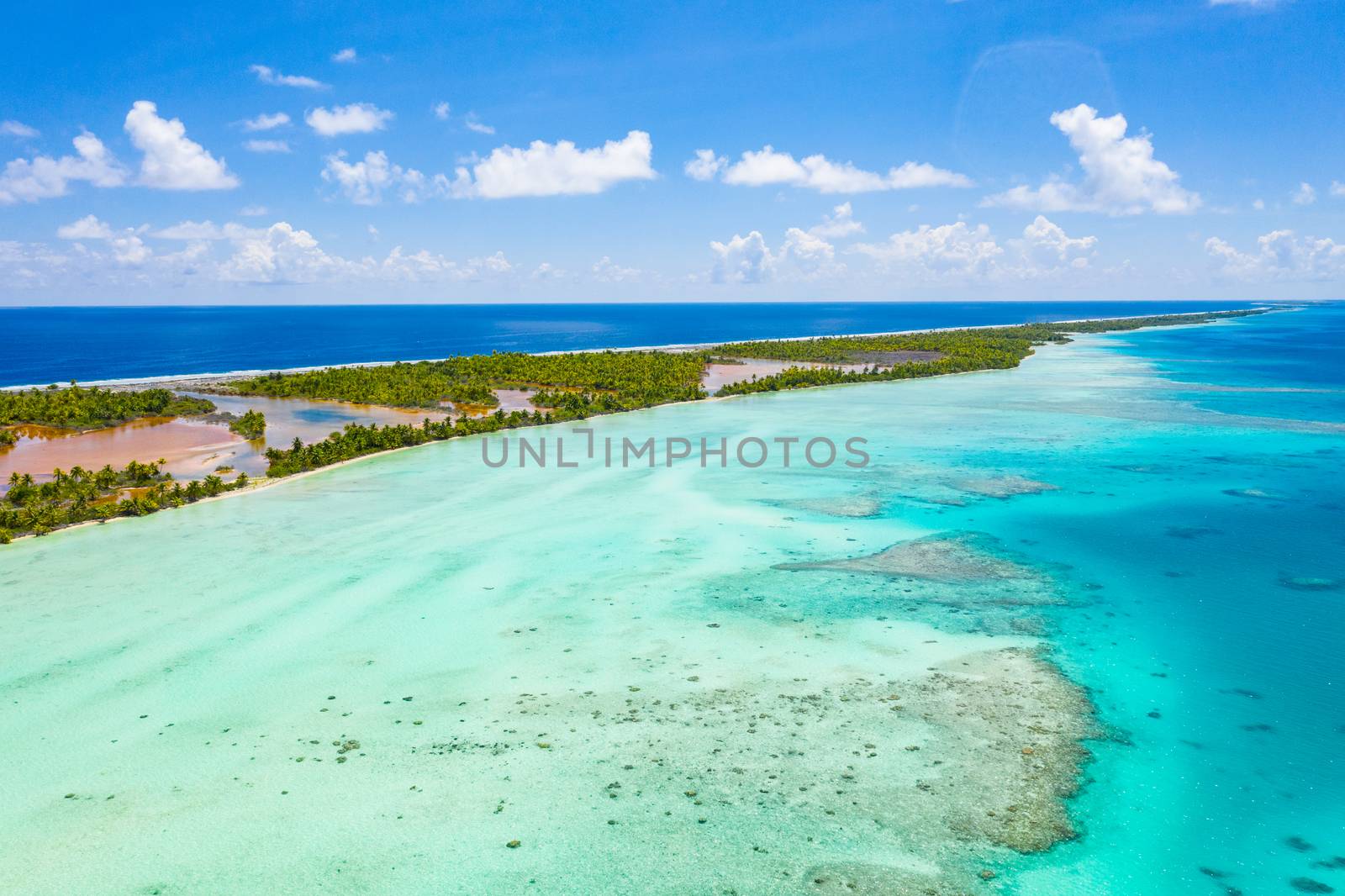 Drone video of French Polynesia Tahiti Fakarava atoll and famous Blue Lagoon and motu island with perfect beach, coral reef and Pacific Ocean. Aerial Tropical travel paradise in Tuamotus Islands.