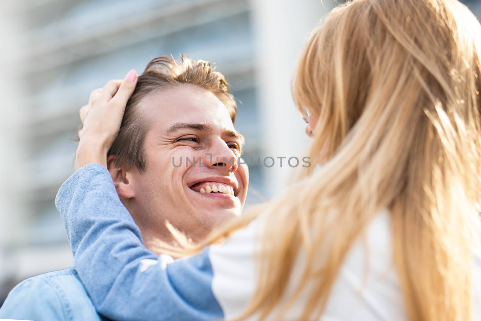 Happy to spending time together. Young beautiful couple outdoor fashion portrait. Attractive boy and girl hugging and kissing.