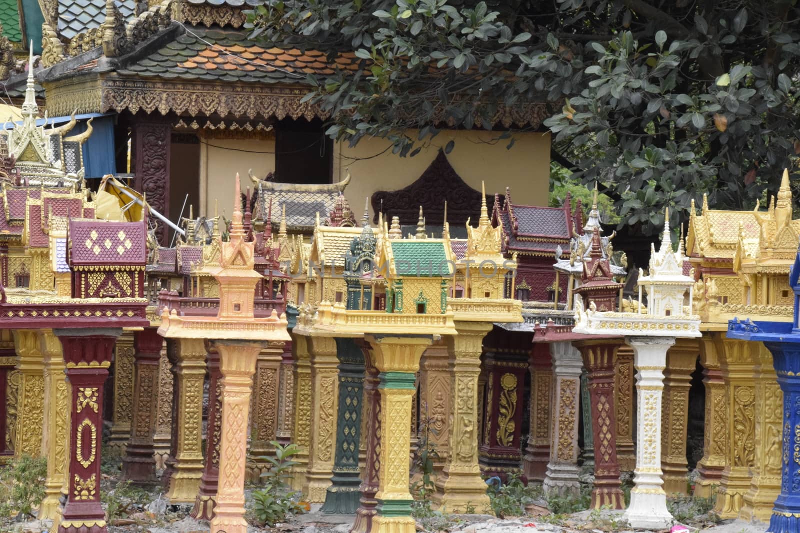 a cluster of spirit houses sit adjacent to a roadside temple ded by mrs_vision