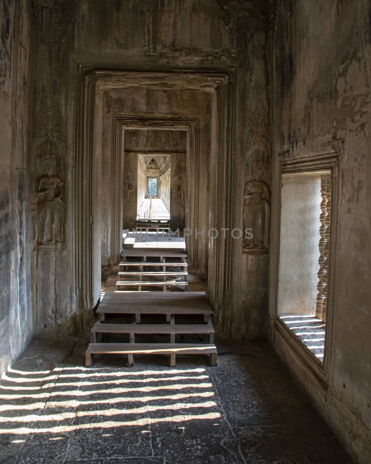 Angkor Wat, Cambodia - March 2016: View along a corridor at Angkor wat. Originally constructed in the early 12th century, the ruins are a huge tourist attraction as well as a place of worship today
