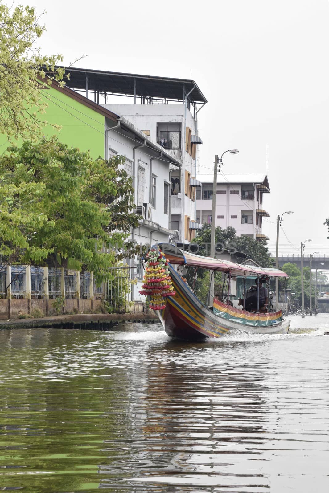 Thailand, Bangkok - March 2016: Longtail taxi boat traveling along the side canals of the city