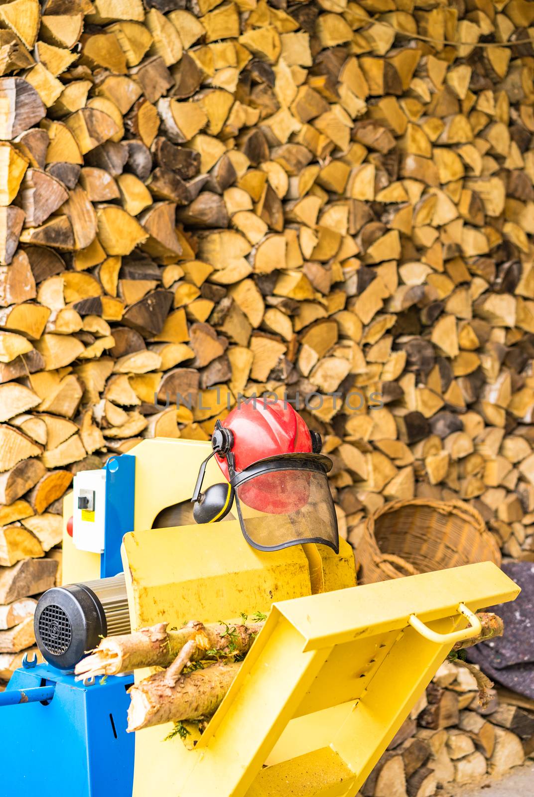 Circular saw in front of a firewood stack