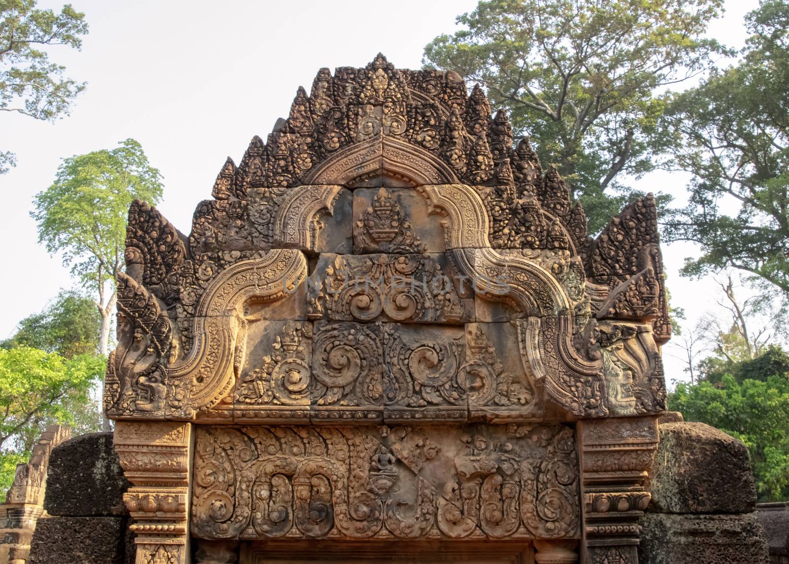 Cambodia, Banteay Seay - March 2016 - Decorative lintels in reconstructed ruins of ornately carved 10th-century, red sand stone, temple dedicated to the Hindu god Shiva, bathed in the early morning light