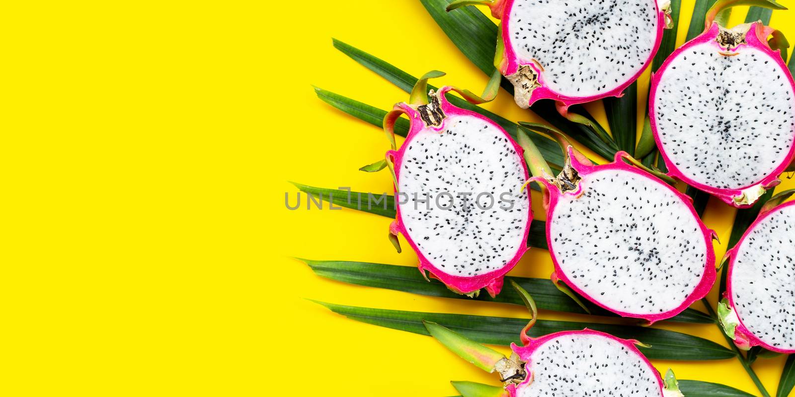 Ripe dragonfruit or pitahaya on tropical palm leaves. Top view