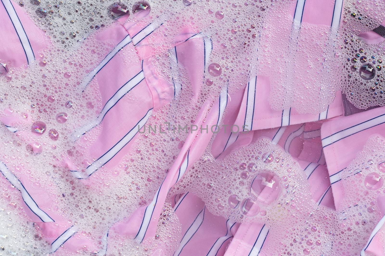 Top view of color clothes soak in powder detergent water dissolution. Laundry concept
