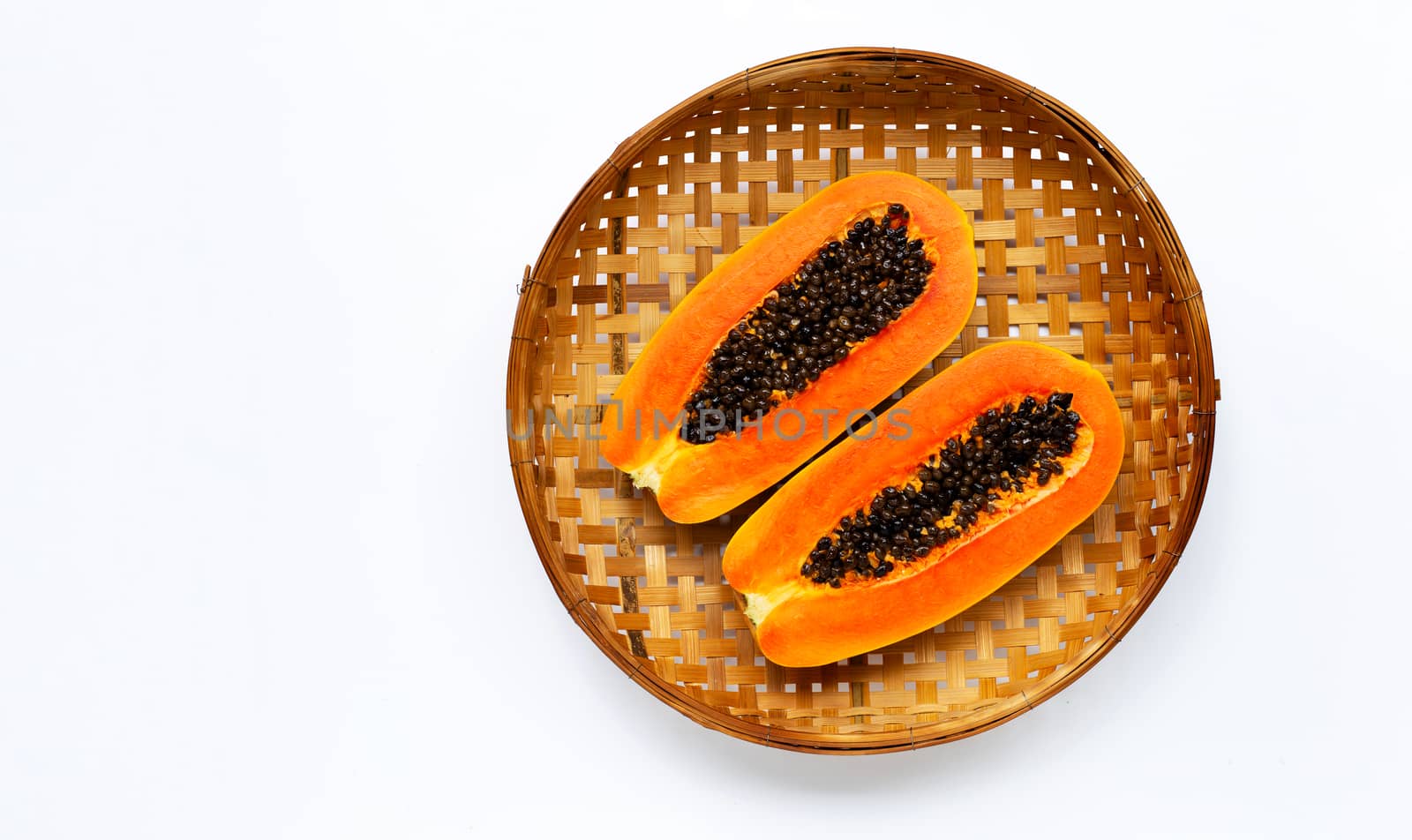 Papaya on wooden bamboo threshing basket on white background. Copy space