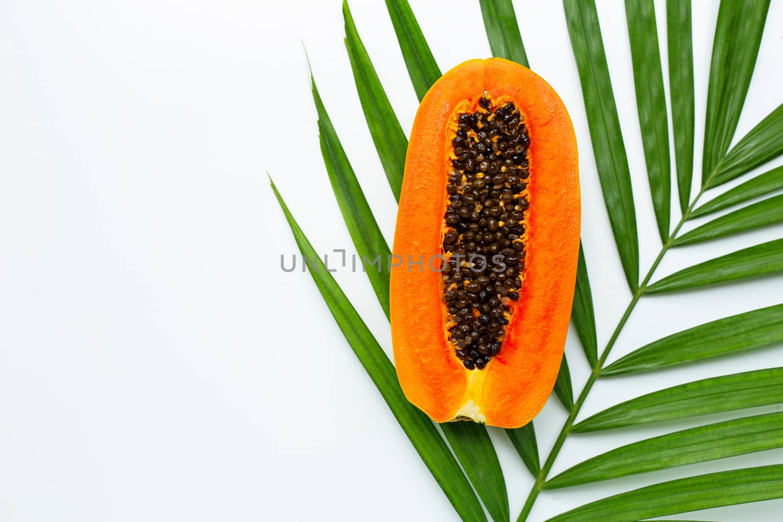 Sweet ripe papaya on tropical palm leaves. Top view