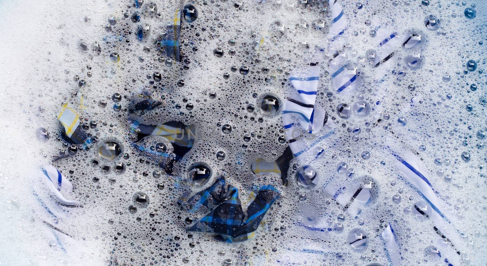 Top view of clothes soak in powder detergent water dissolution. Laundry concept