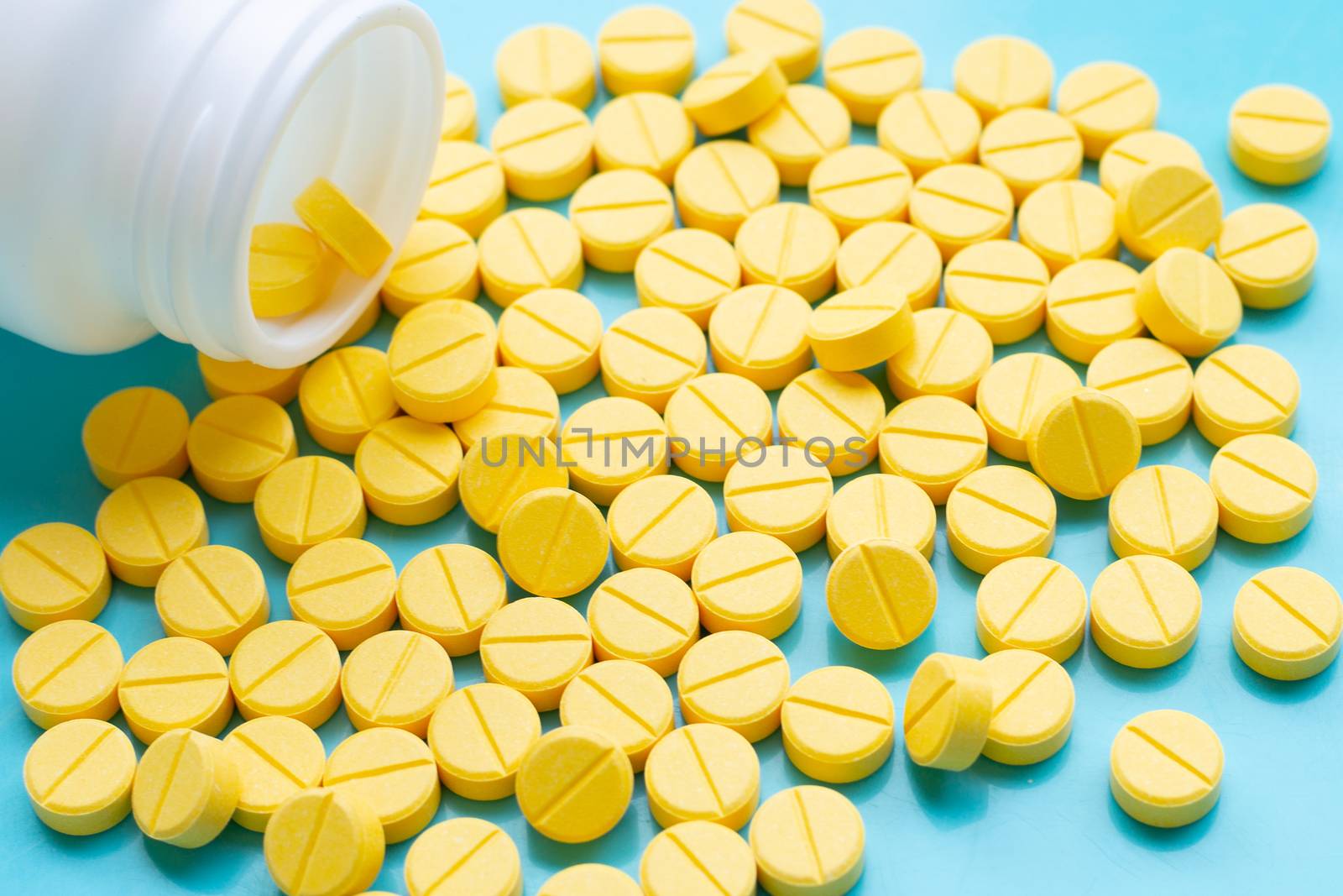 Yellow tablets of Paracetamol on blue background.