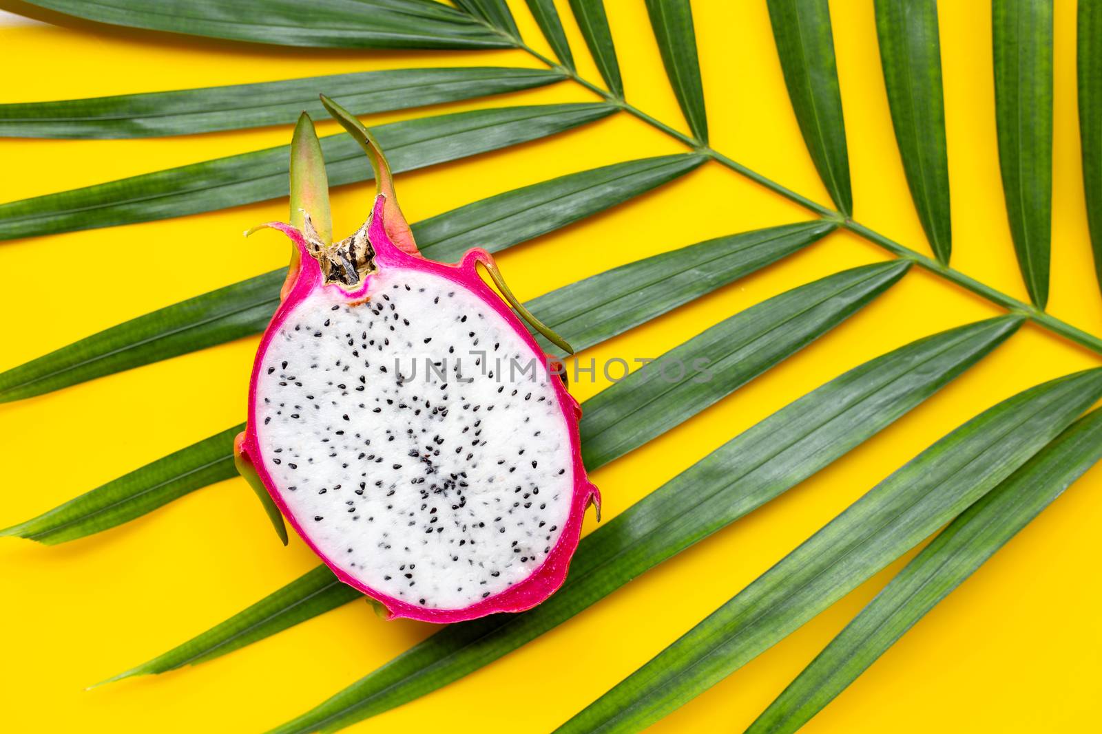 Ripe dragonfruit or pitahaya on tropical palm leaves. Top view