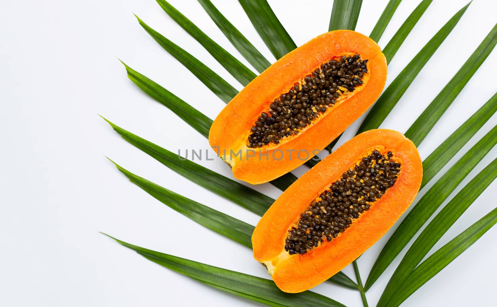 Sweet ripe papaya on tropical palm leaves. Top view