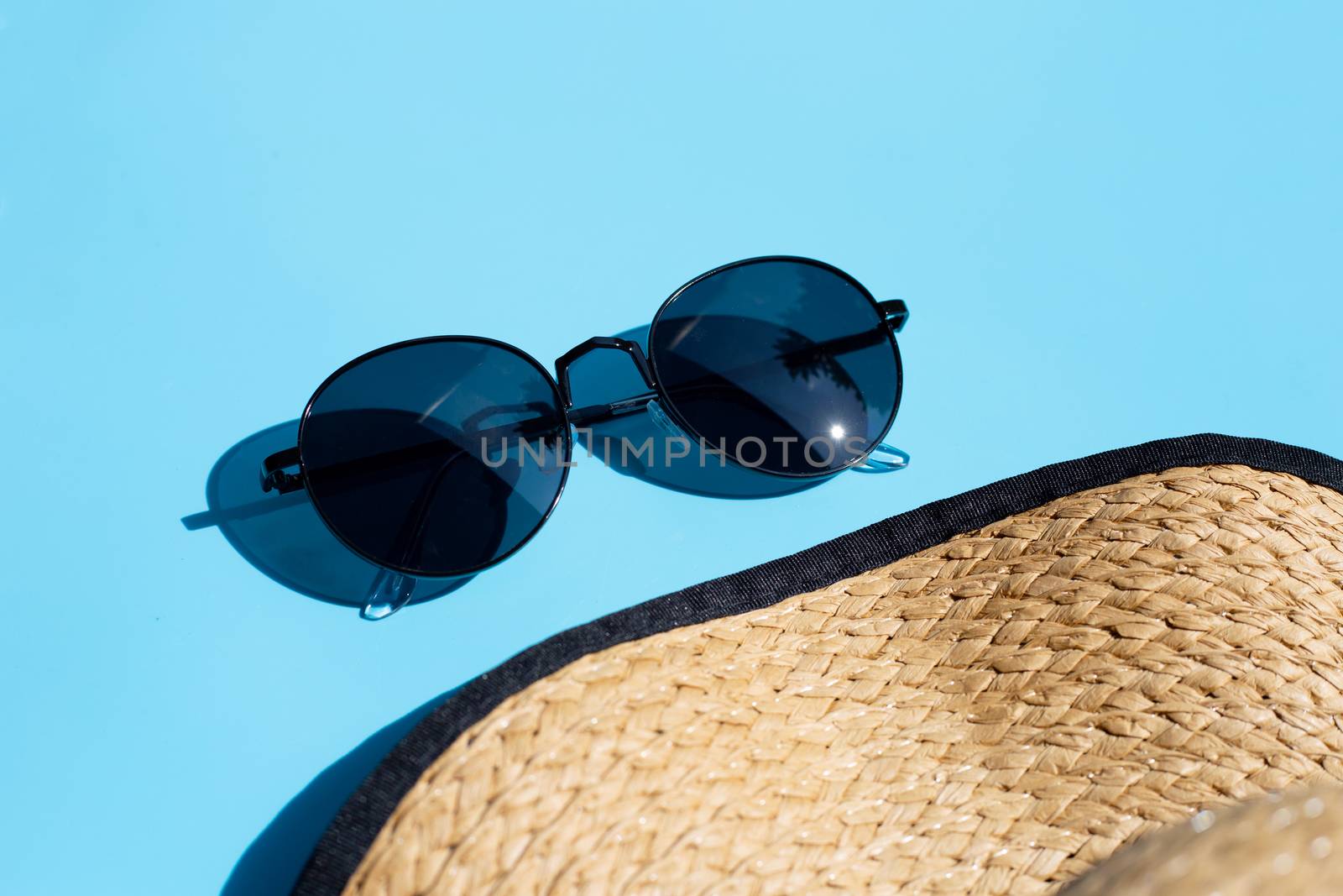 Sunglasses with summer hat on blue background. Enjoy holiday concept. Copy space